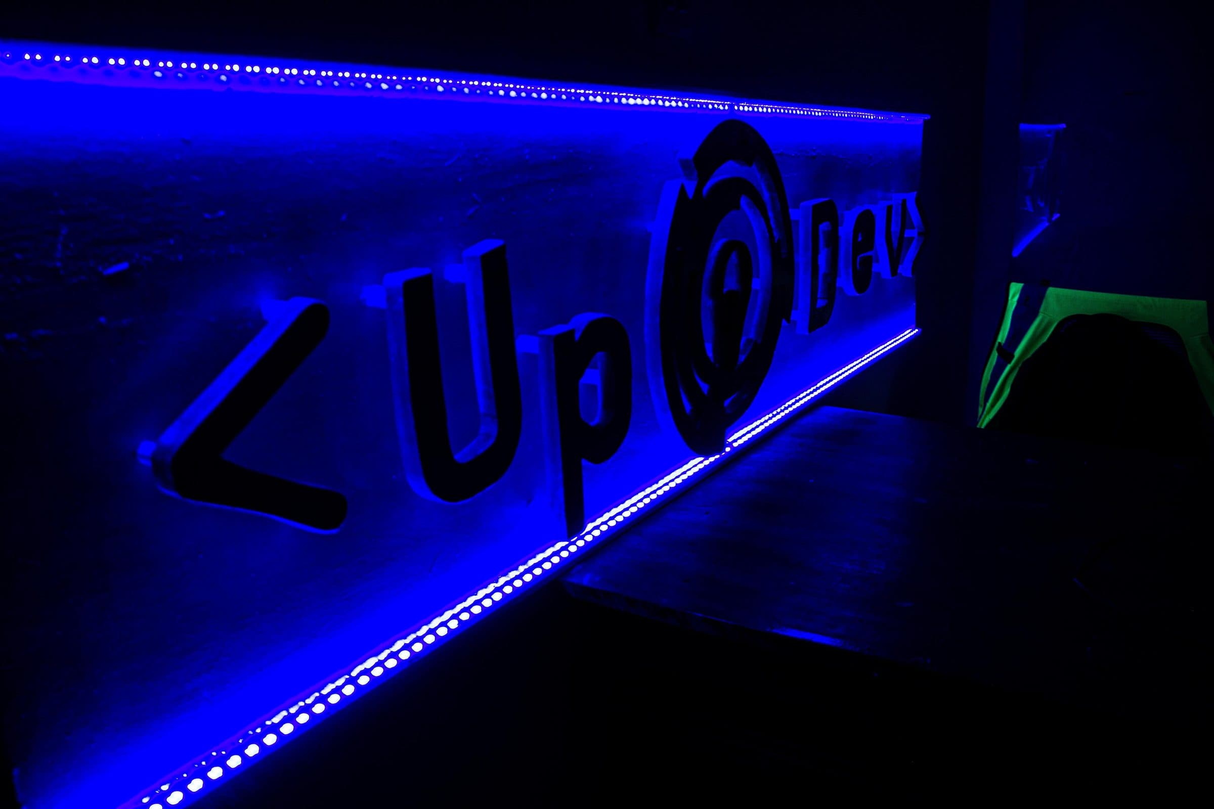 L’enseigne lumineuse du studio UPDEV, éclairée en bleu
